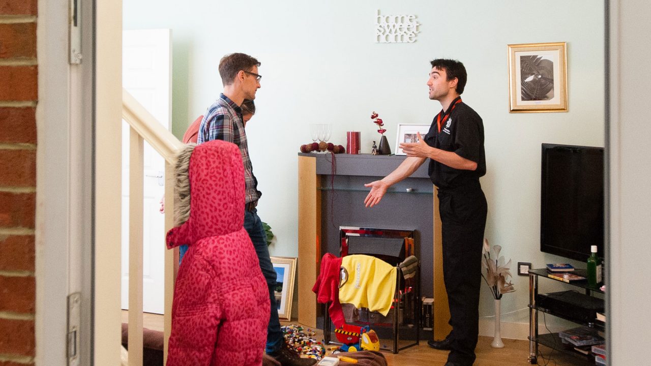 Students and lecturers stood inside living room in home