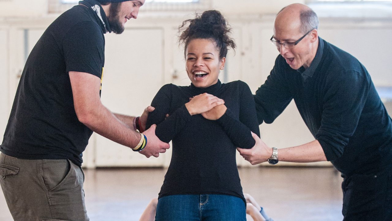 Girl falling backwards in trust exercise with big smile on her face