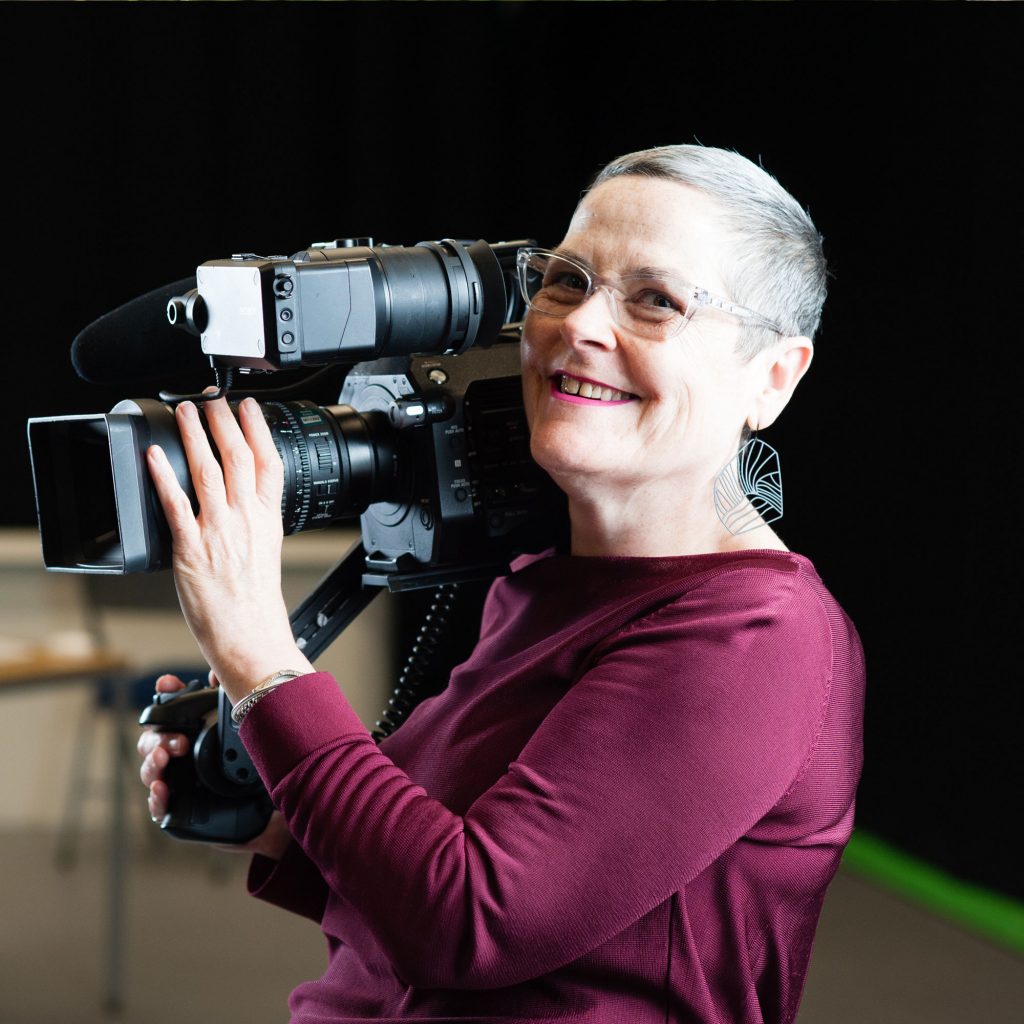 Fiona Curran, Lecturer in Media, smiling holding camera