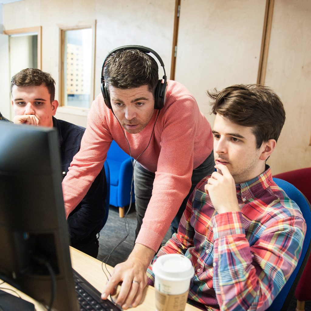 lecturer standing by student's computer screen