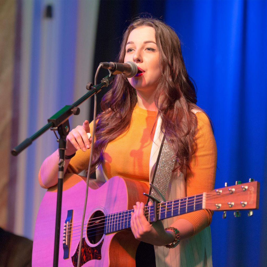 Student performing with guitar