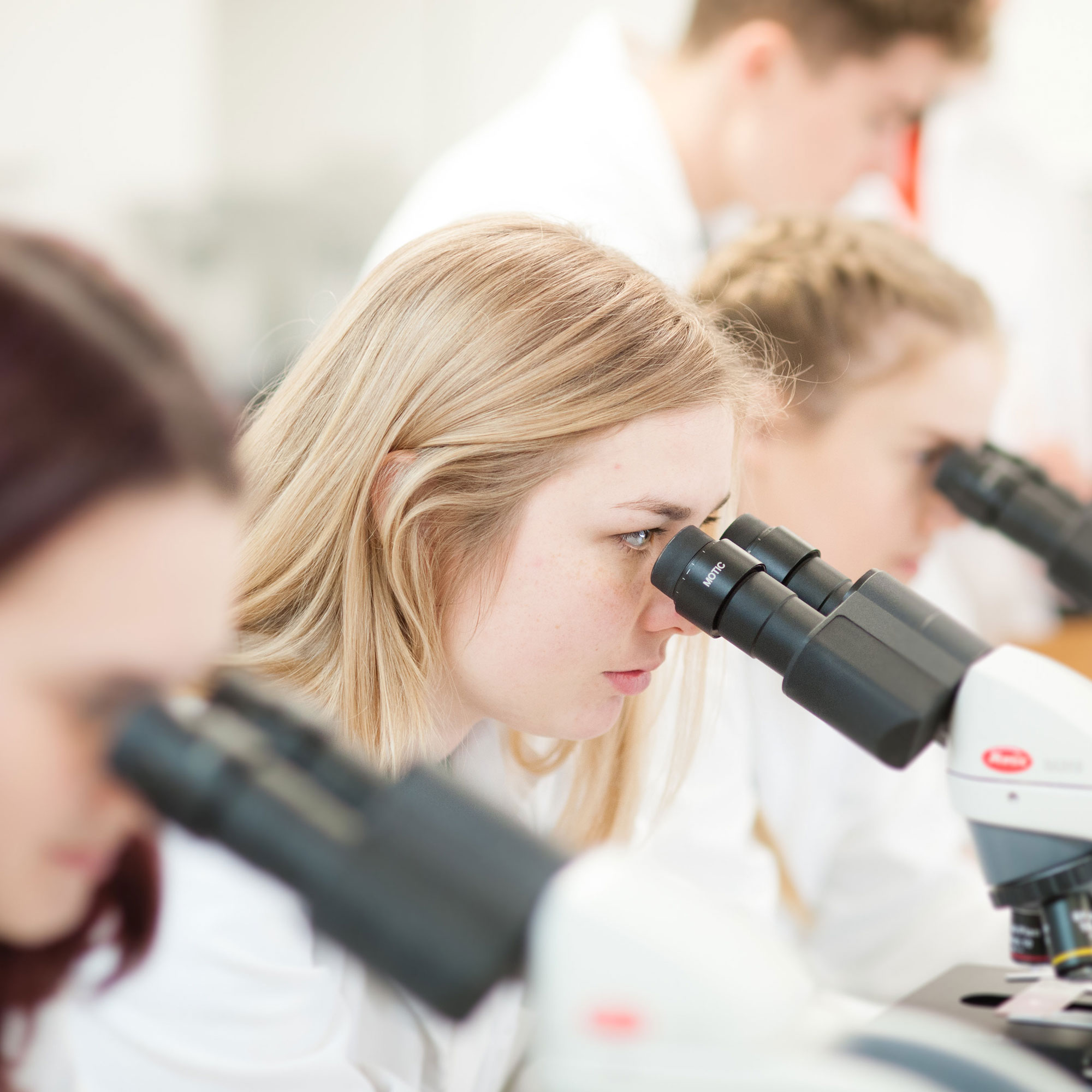 Female student looking down a microscope