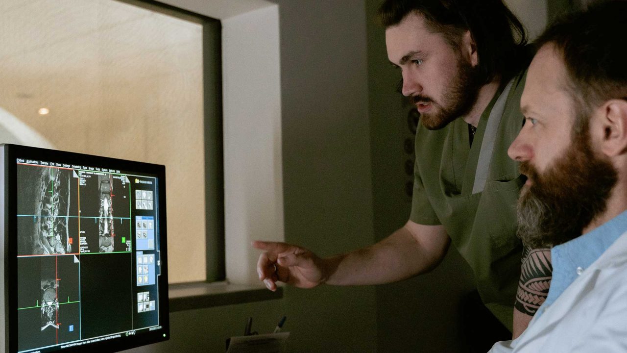 Two Diagnostic Radiographers assessing images on a computer screen