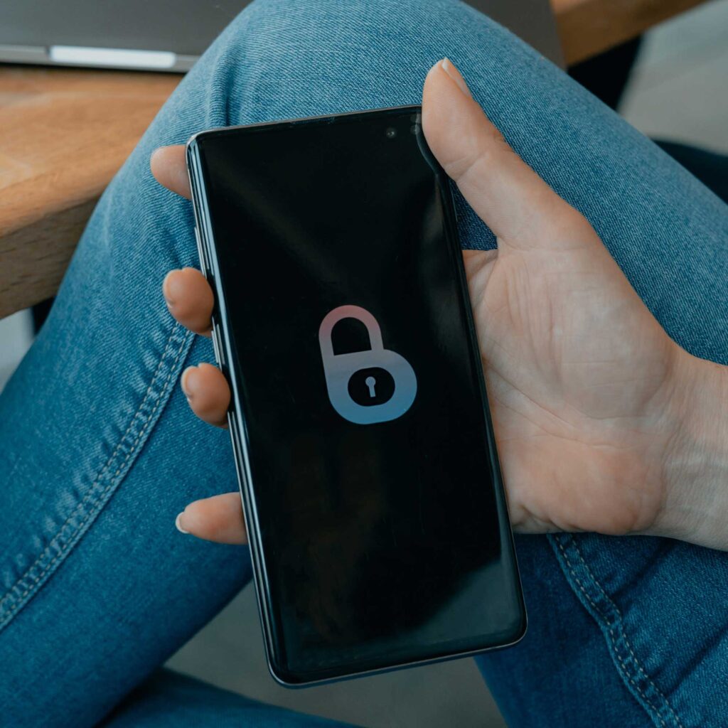 A person holding a mobile phone with a picture of a padlock on the screen.