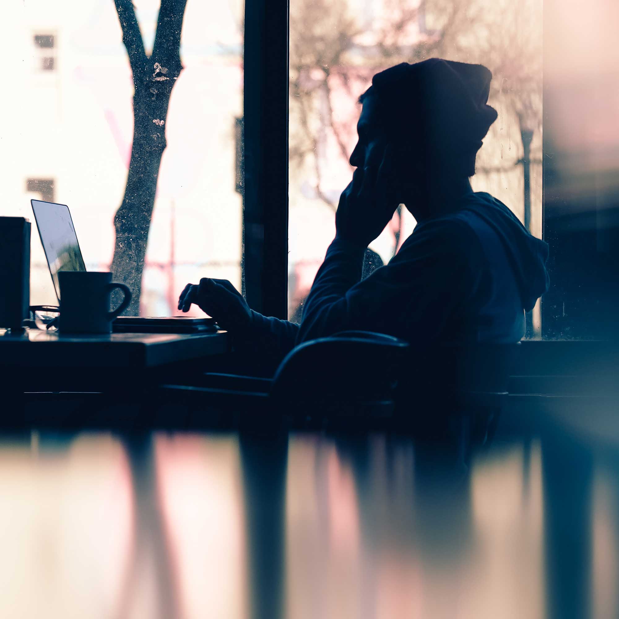 Man sitting in a cafe using a laptop