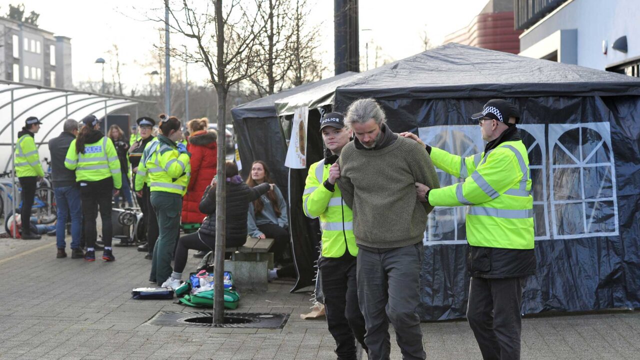 Two student police offers escort a criminal from the scene of an incident.