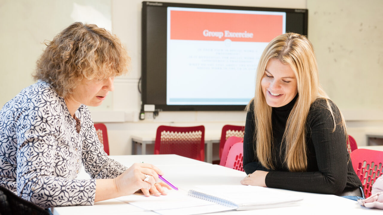 two women at a desk looking at a document