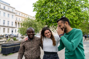 Three students laughing while walking down Cheltenham Promenade.