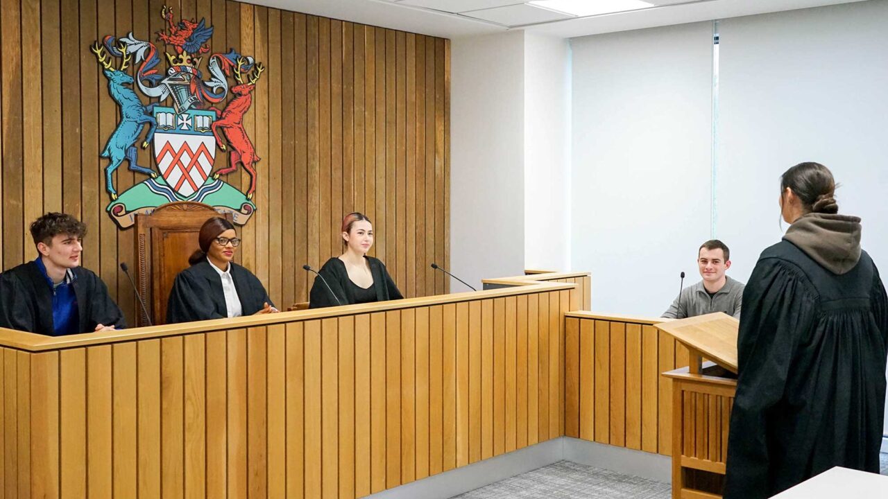Students in robes in UOG's moot court.