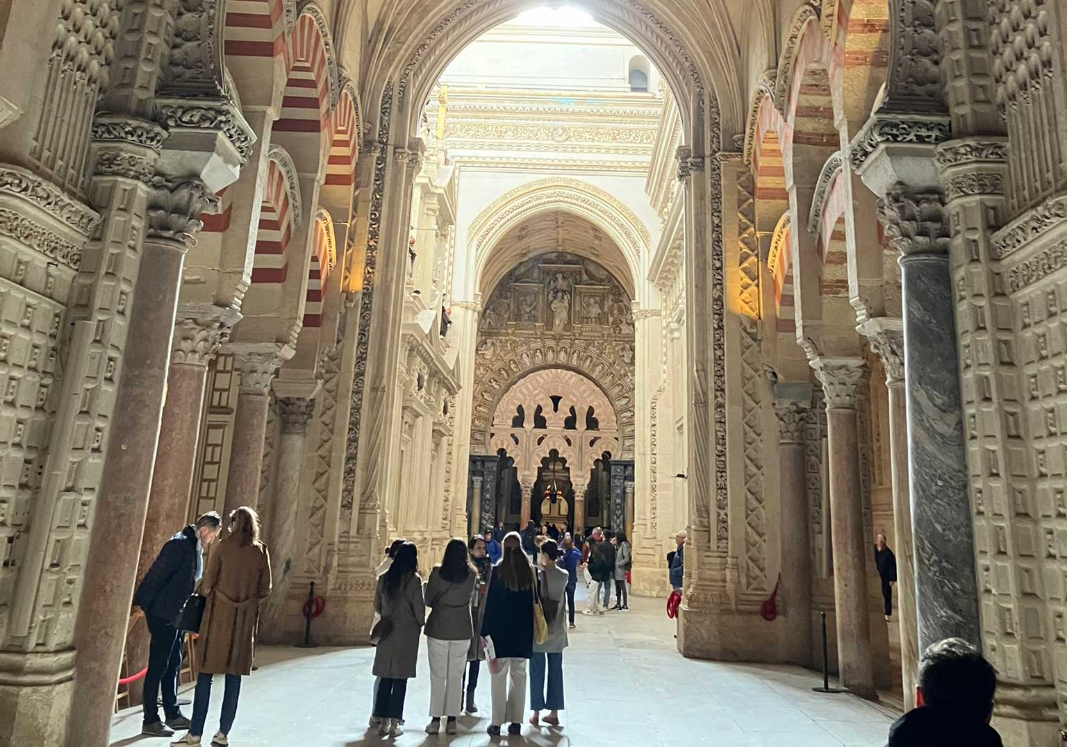 Visitors stand in the ornately carved interior of the Mesquita Mosque-Cathedral.
