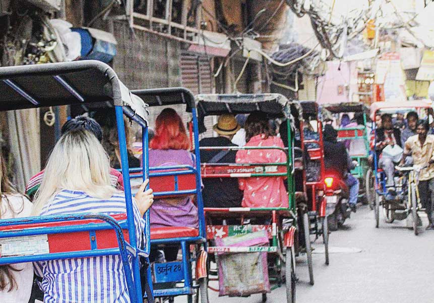 A busy narrow street in Old Delhi full of rickshaws