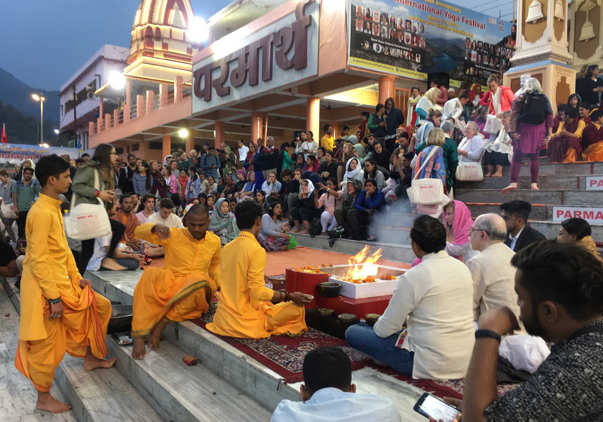 People sit on steps around a fire Parmarth Niketan Ashram in Rishikesh.