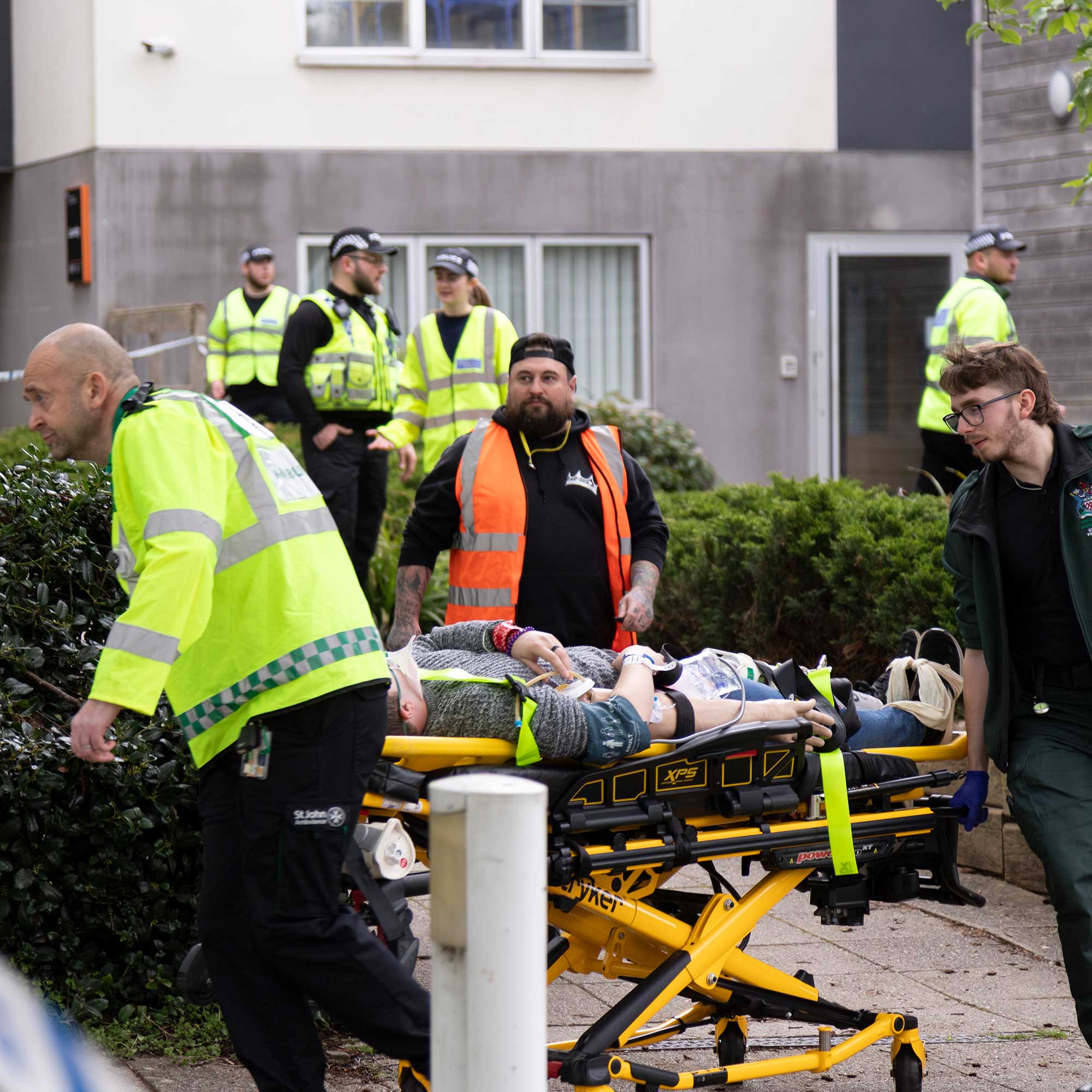 Paramedic students wheeling a 'casualty' on a stretcher.