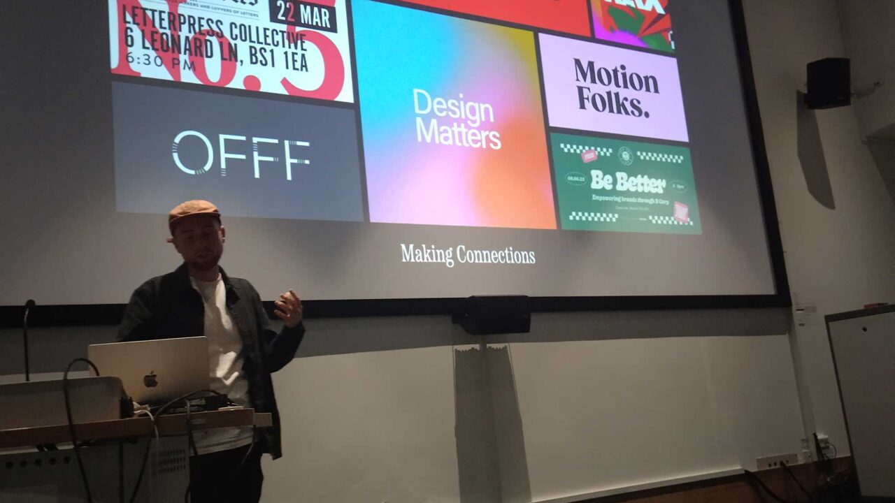 design-matters A student stands gives a presentation in front of a display screen showing design organisation logos.