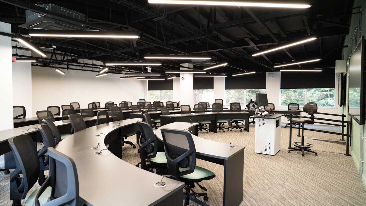 Computing suite at FuturePark showing desks in a semi-circle and two large flat screens at the front.