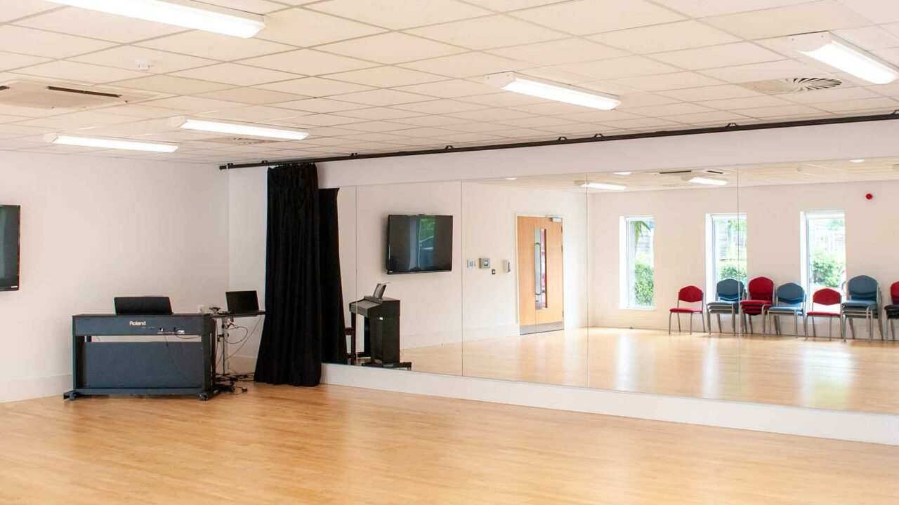 The Garden Studio at Oxstalls with a mirror, black curtain and piano set up.