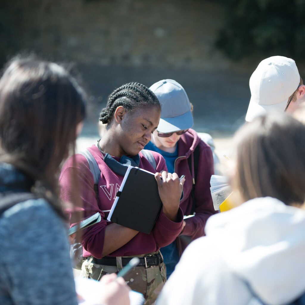 A groups of students on a field trip making notes.