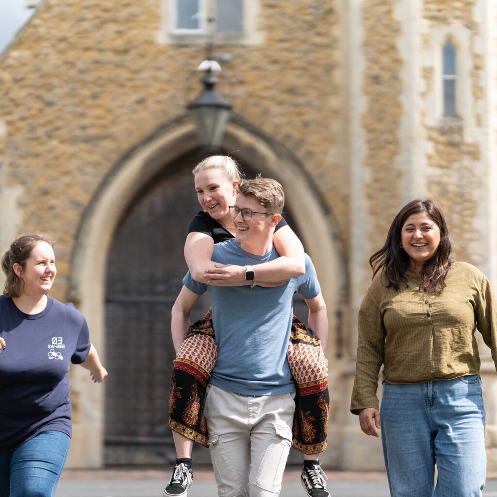 Students walking away from the arched doorway of Francis Close Hall.