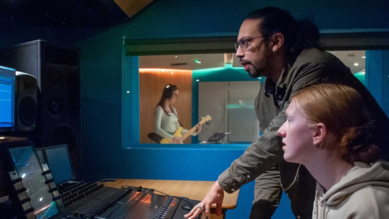 Two students using an audio mixing desk