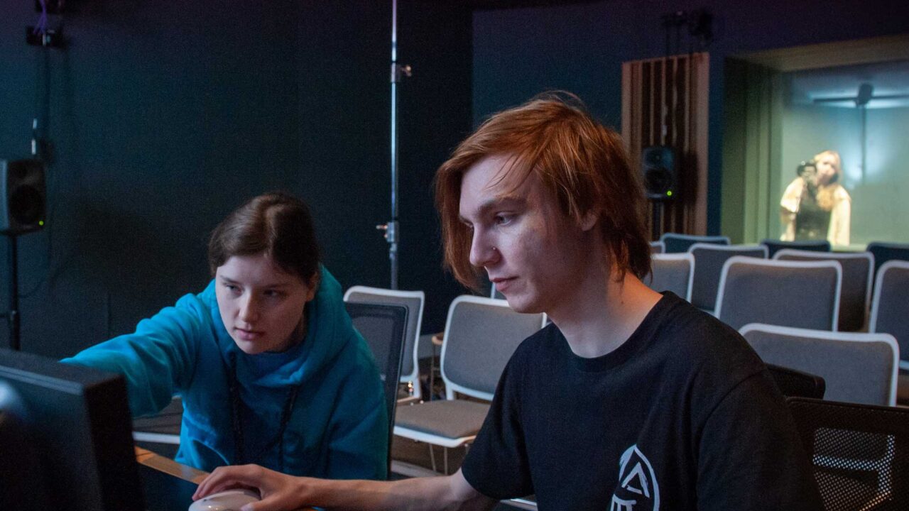 Two students using an audio mixing desk