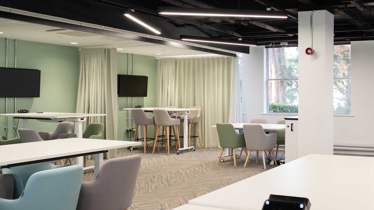 FuturePark social space with chairs, raisable desks and screens.