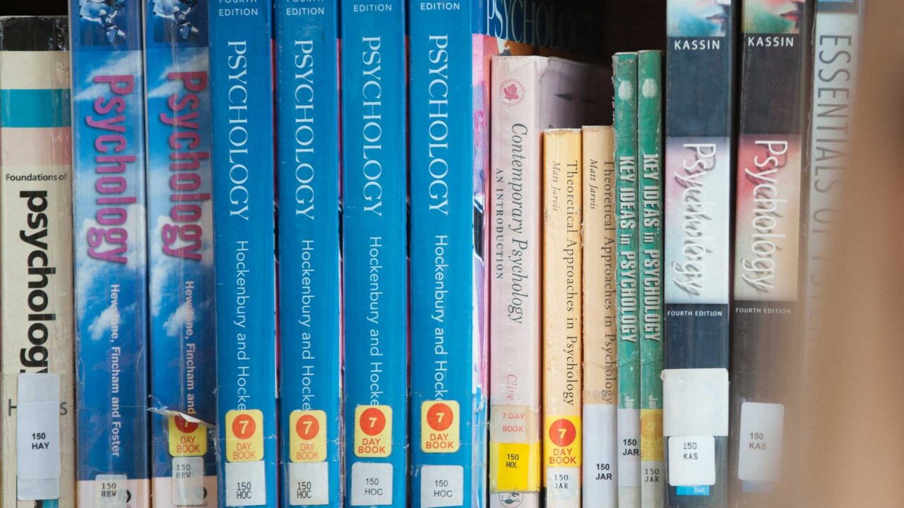 Psychology textbooks on a library shelf.