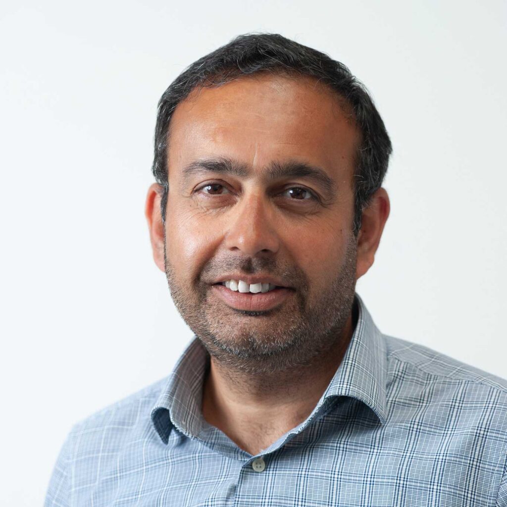 Head and shoulders photo of Wajid Minhas smiling.