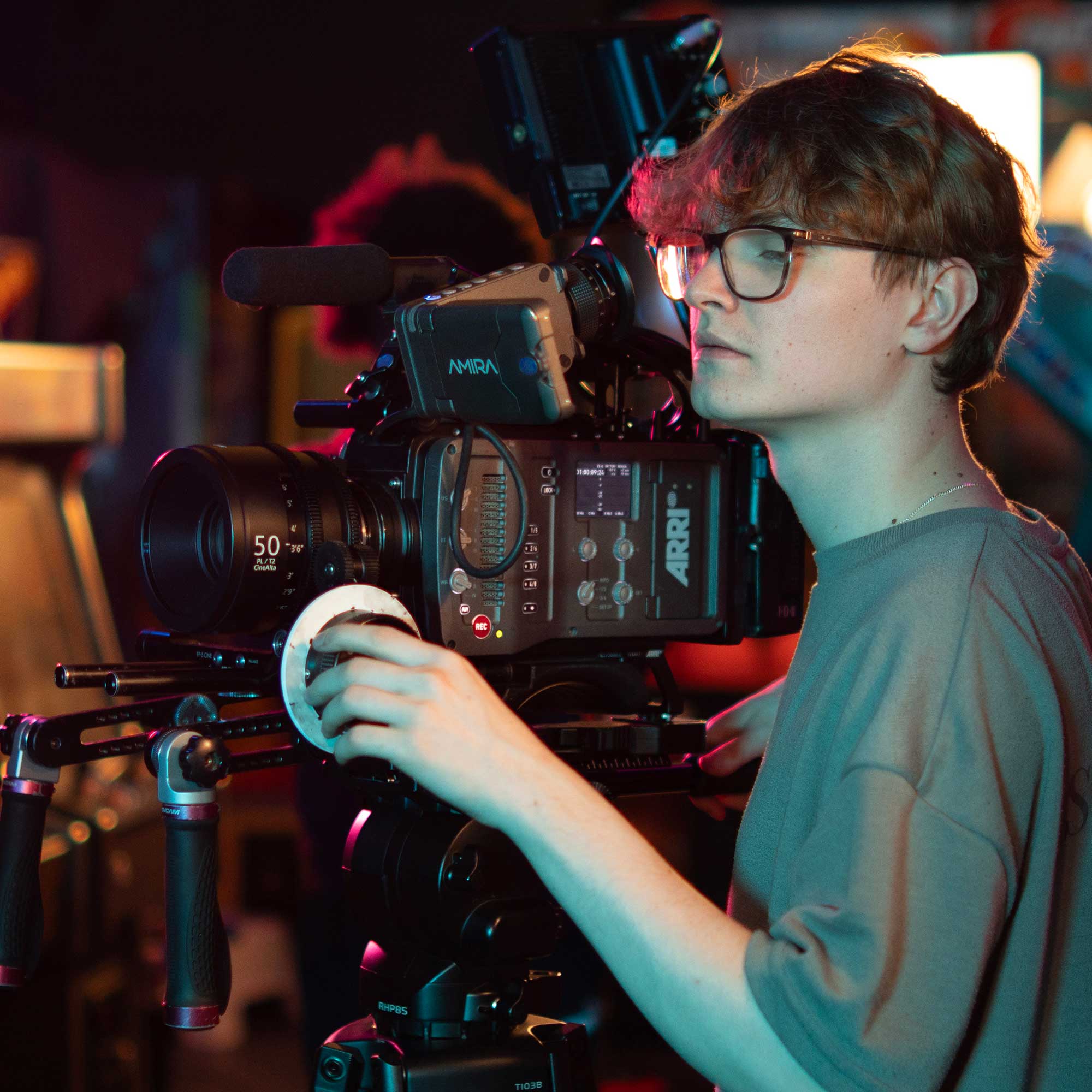 A Film and TV Production student operating a camera in a studio