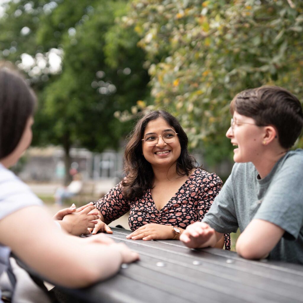 Students sit at a picnic bench at Oxstalls.