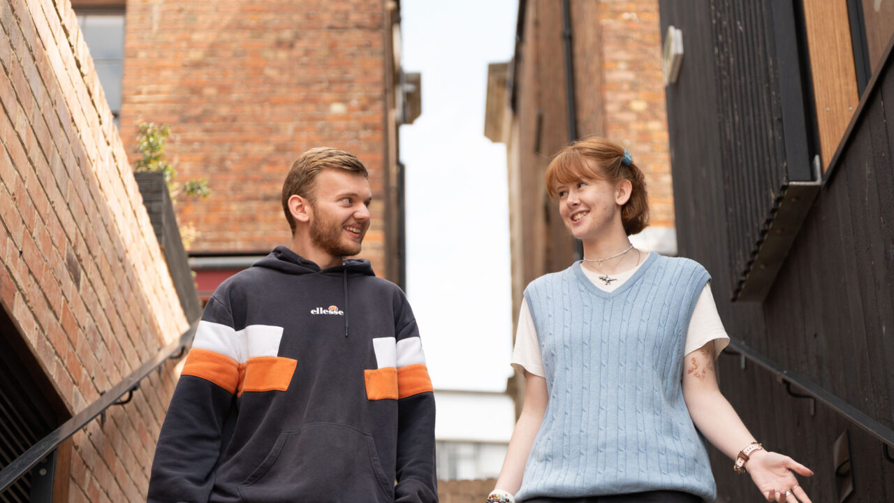 Two students walking down steps in Gloucester City Centre