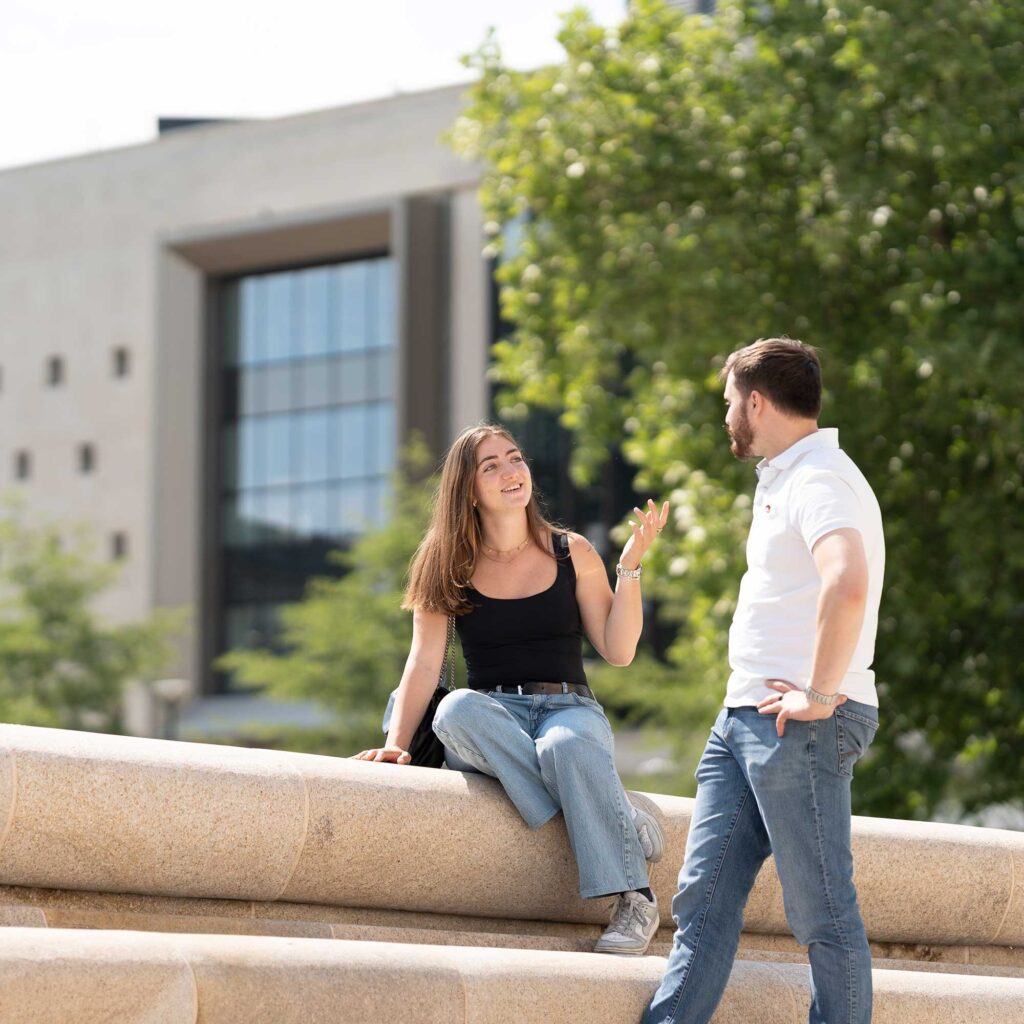 Two students talk to each other in Kings Square, Gloucester.