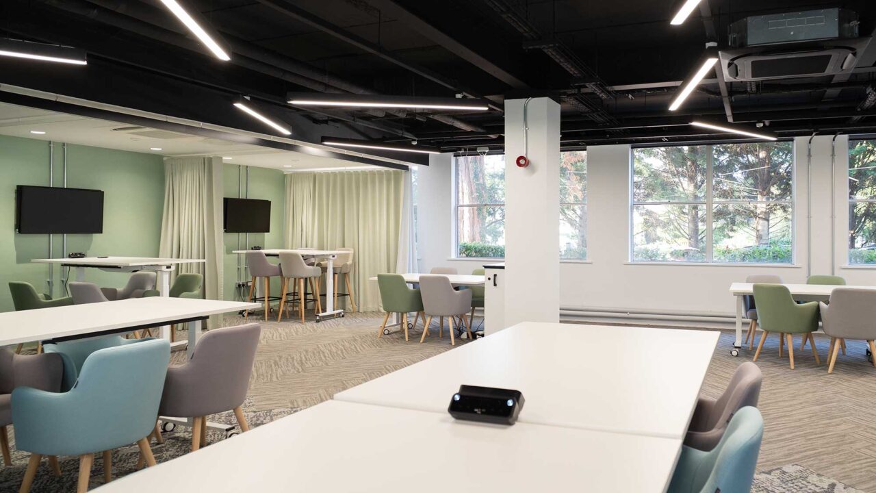 Relaxed work spaces at FuturePark featuring tables, chairs, meeting spaces and flat screens.
