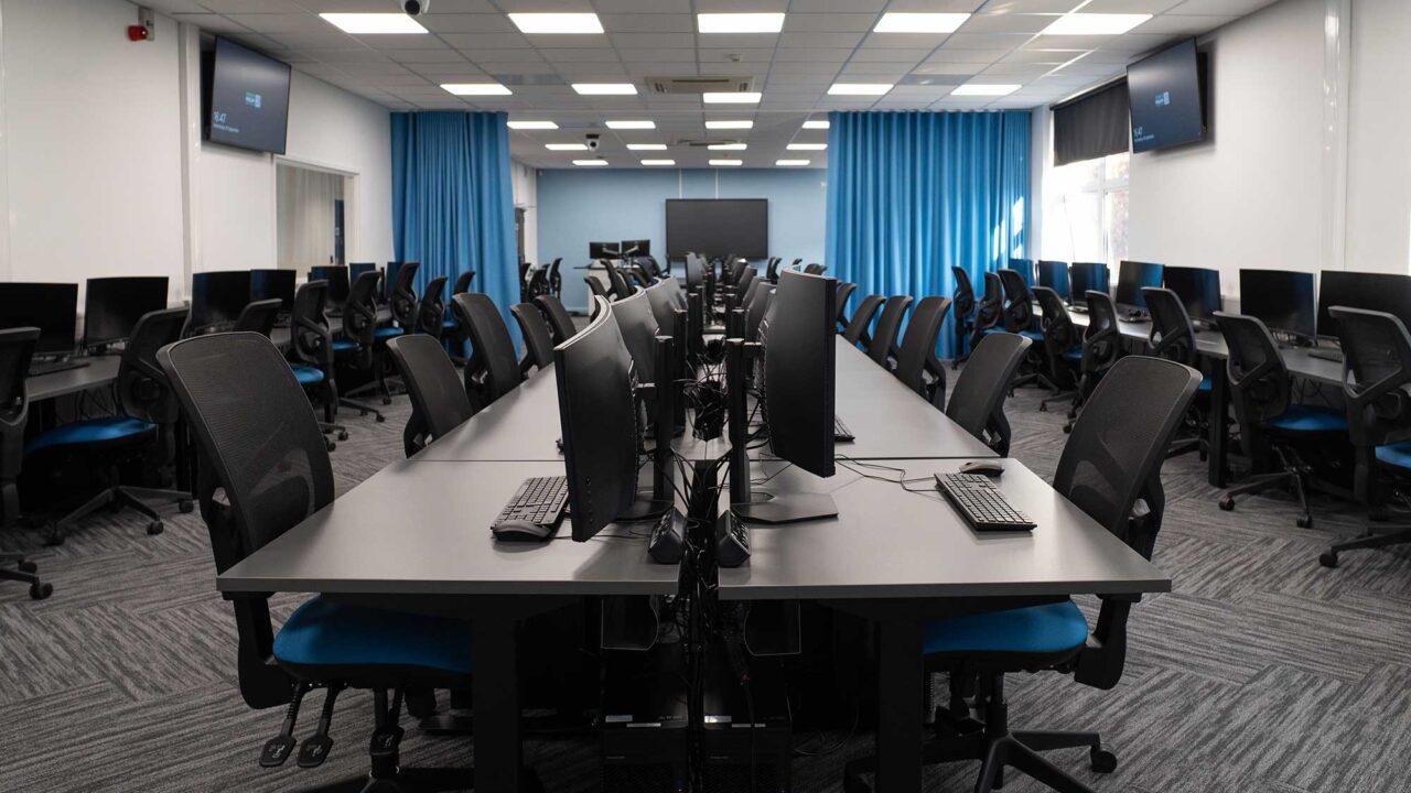 A teaching space featuring multiple computer workstations.