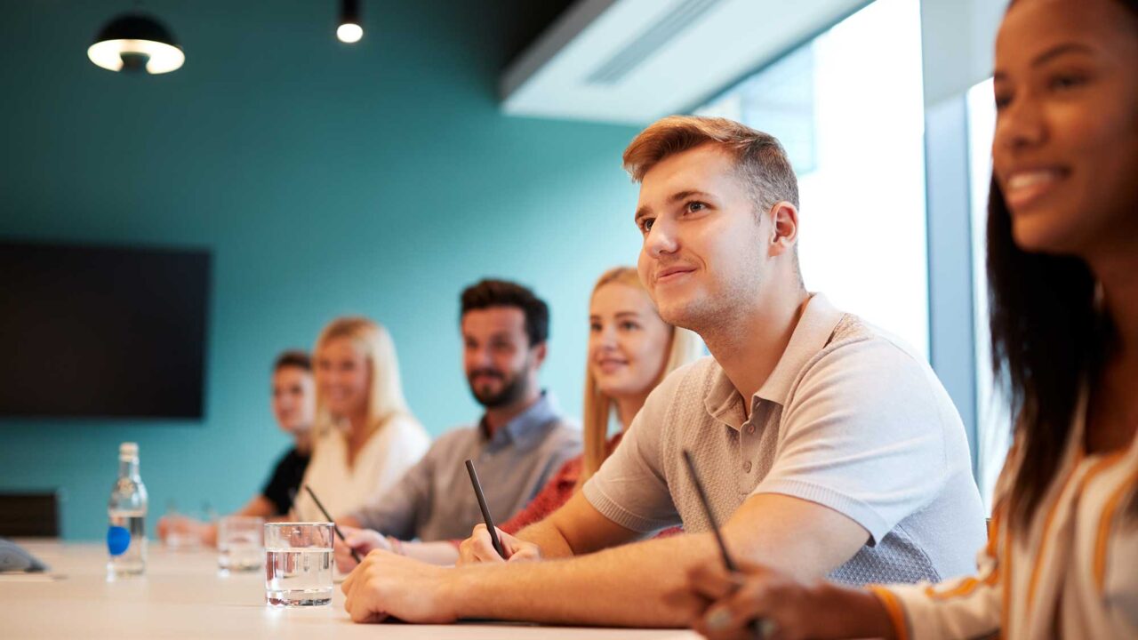 Students sitting at a table with paper and pencils.
