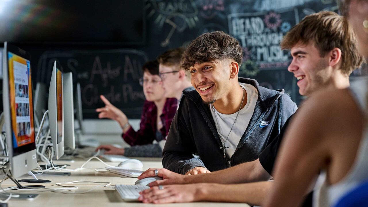 Students working on computers together.