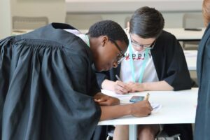 Students wearing gowns in the mock courtroom at Oxstalls Business School