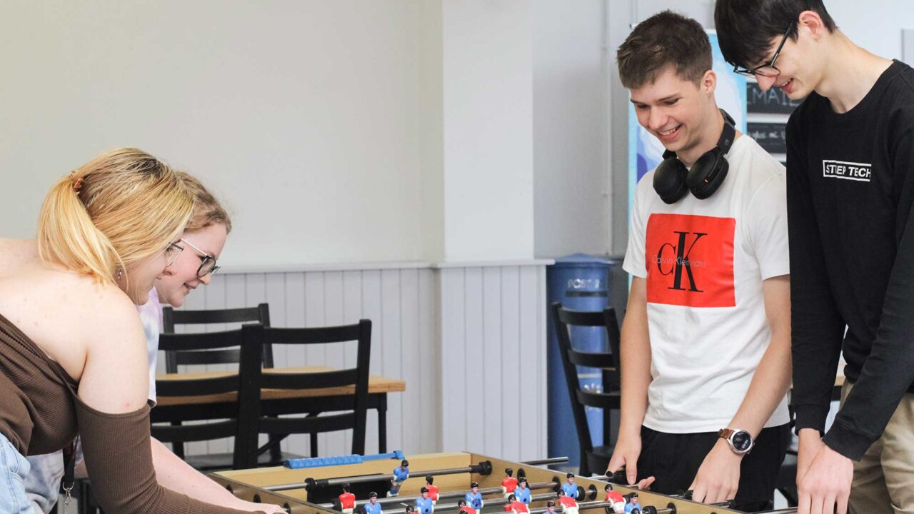 Year 12 students playing table football during the summer residential.