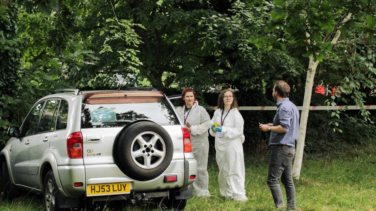 Year 12 students examine a mock crime scene during the summer residential.