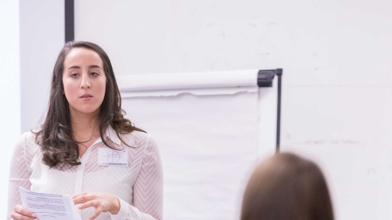 financial-planning-masters-stage A speaker in smart dress presents to an audience