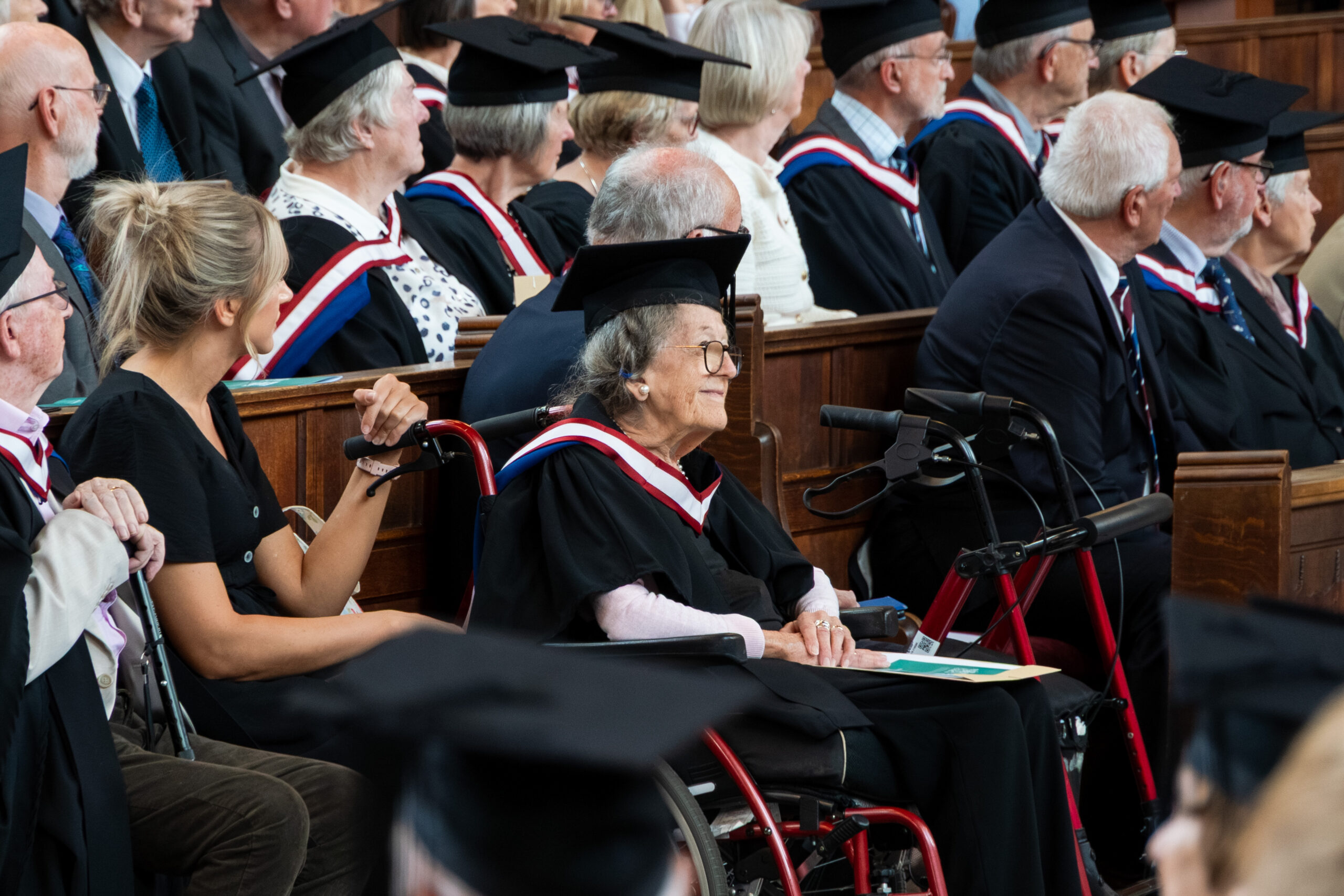 Graduates dressed in caps and gowns sitting in the pews in the Chapel at Francis Close Hall Campus looking towards the alter.