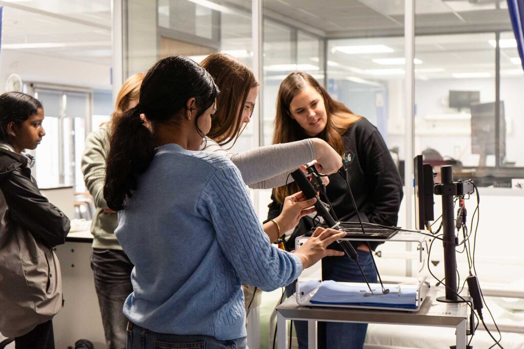 Students examine a piece of health and social care equipment.