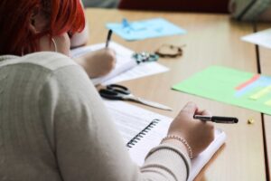 A student writing in a notepad during a taster day.