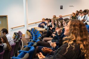 A group pf secondary school children sat in the lecture theatre on campus.