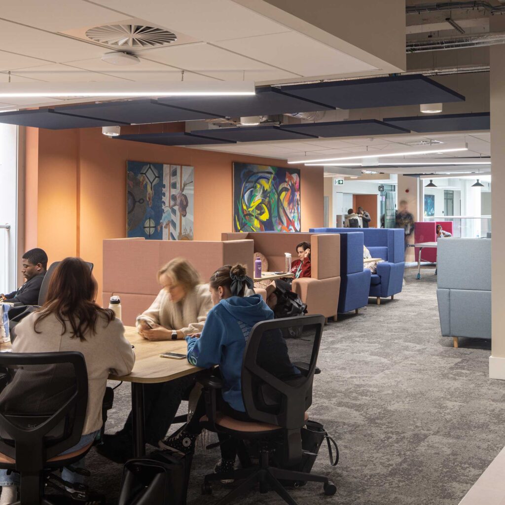 Students sitting in the soft seating areas inside City Campus.