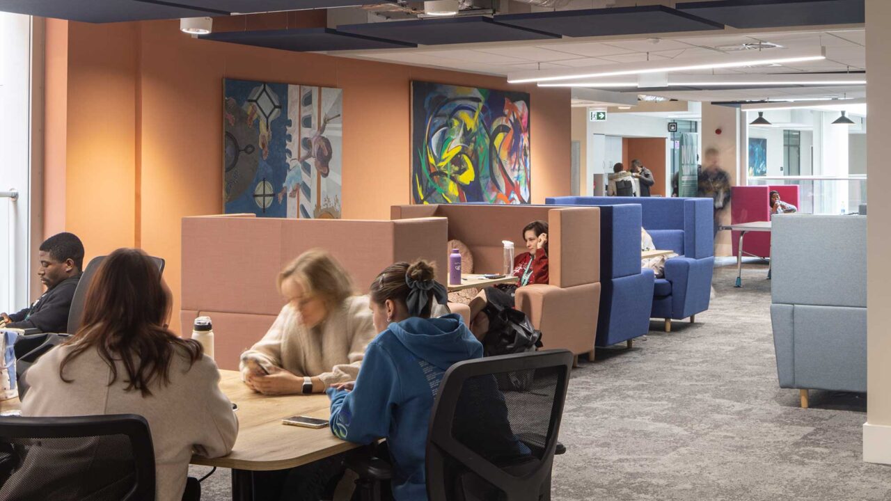 Students sitting in the soft seating areas inside City Campus.
