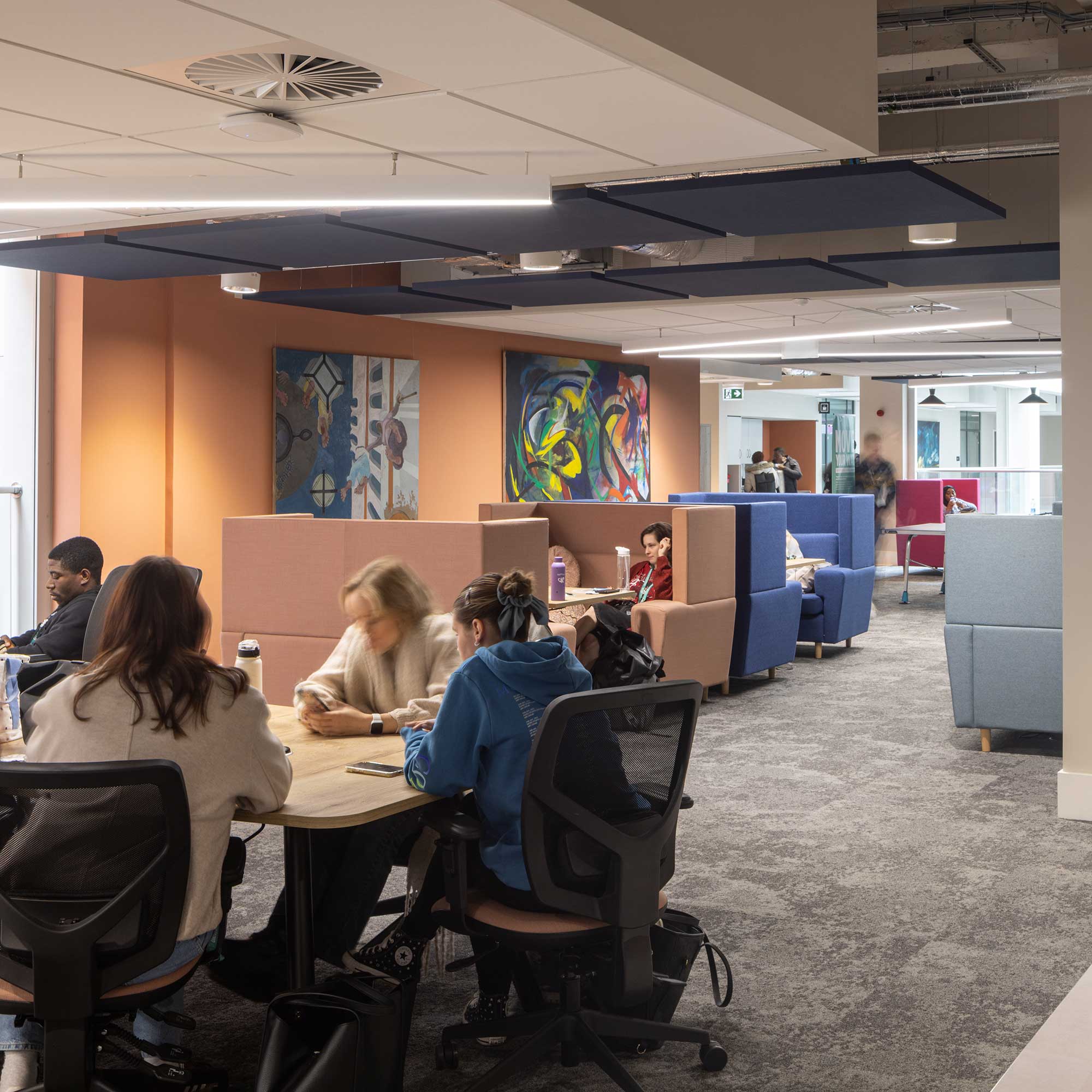 Students sitting in the soft seating areas inside City Campus.