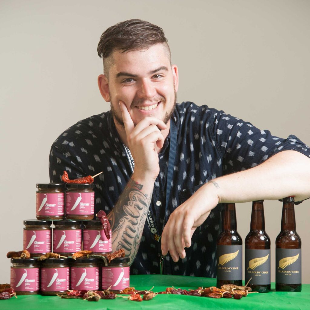 Man with jars of chilli chutney and bottles of All Golds' Cider.