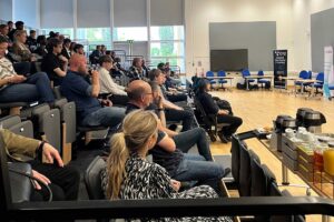 Audience members watching a presentation at the Cyber and Digital Launchpad event.