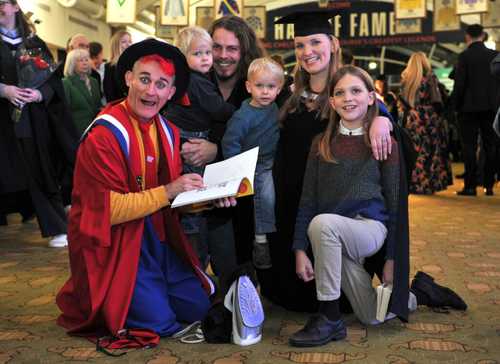 Honorary Fellow, Tweedy, signs book for University of Gloucestershire graduate and family.