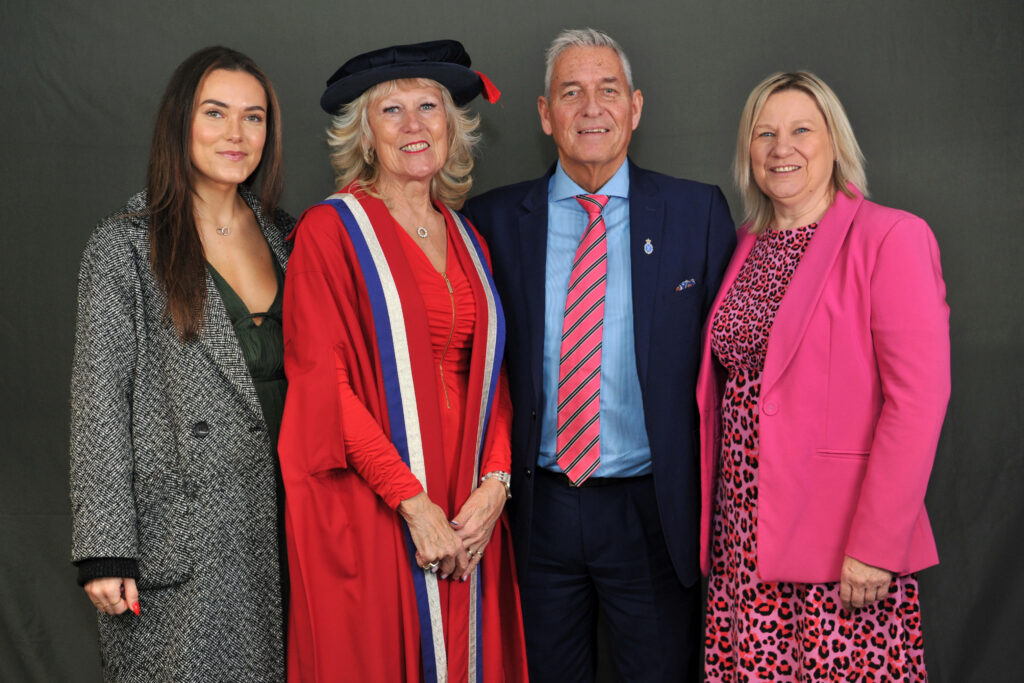 Julie Kent MBE, in cap and gown with daughter on her left, husband on her right and sister next to her husband.